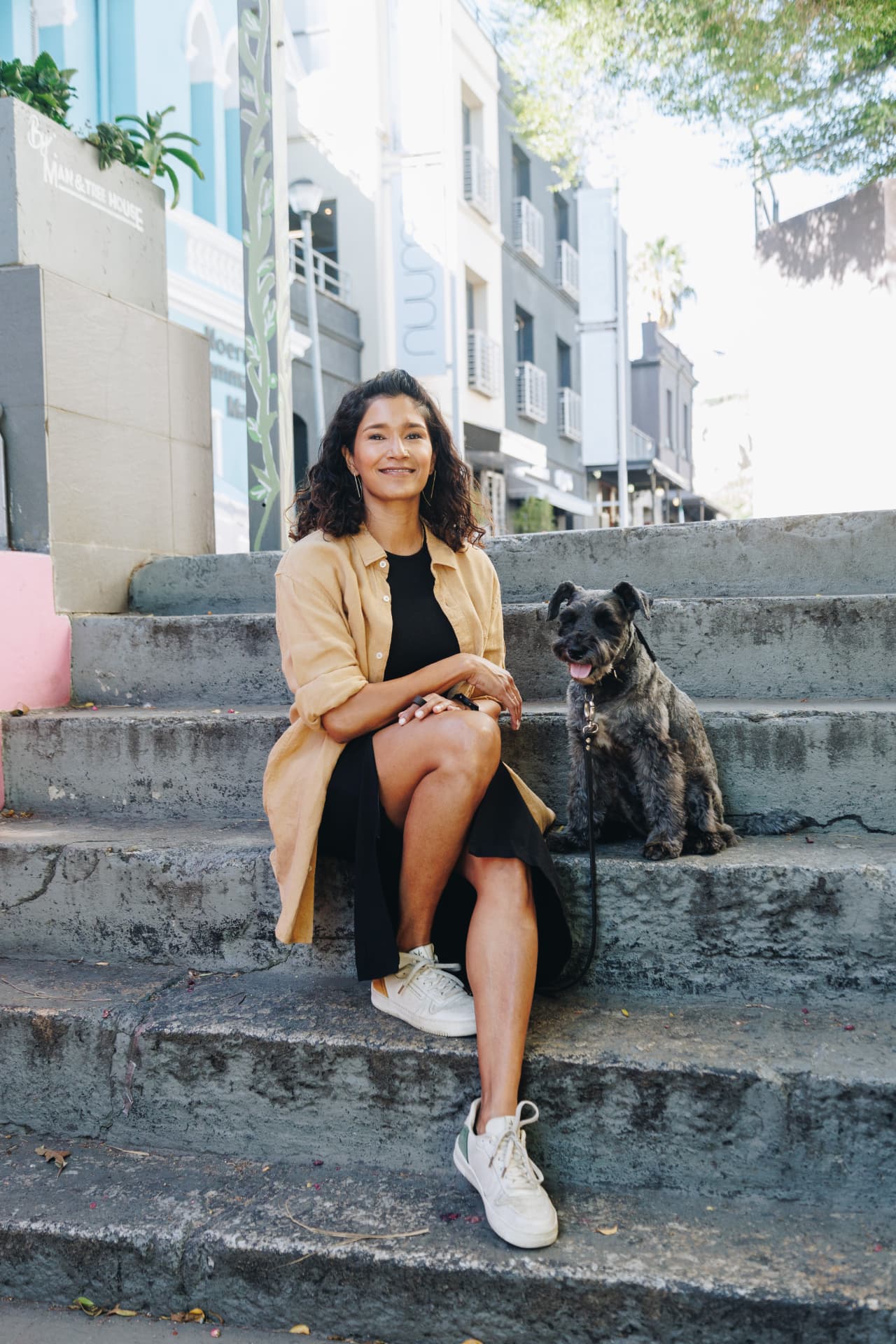 Kamini Pather sitting on city steps with her dog